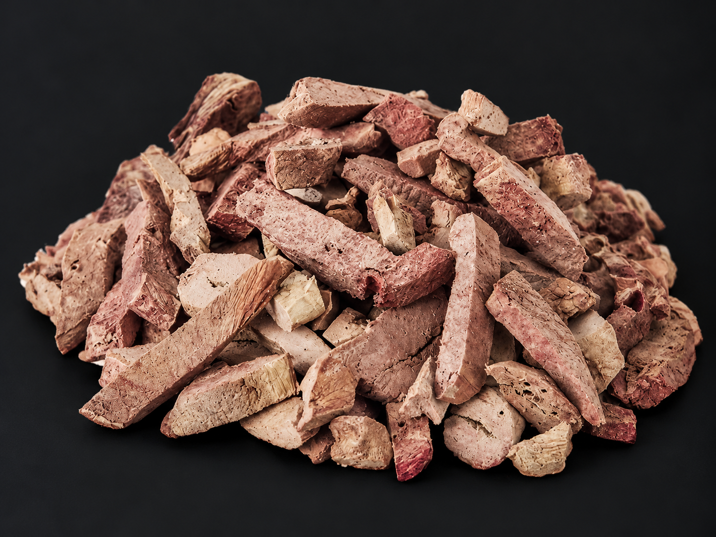Loose freeze-dried lamb liver treats on a charcoal background